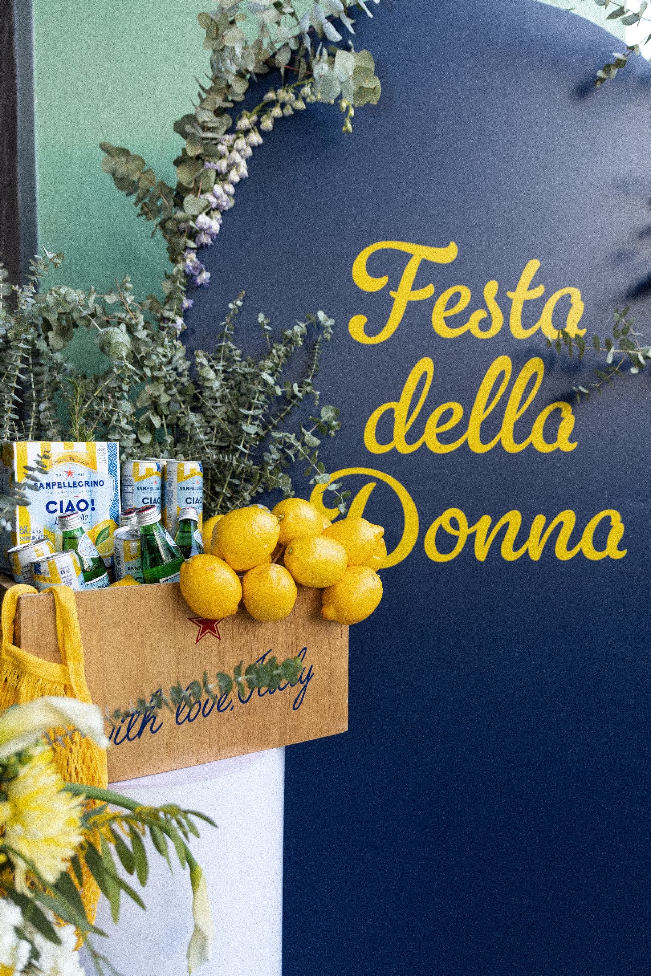 Festa della Donna signage with Sanpellegrino CIAO! cans, lemons, and eucalyptus