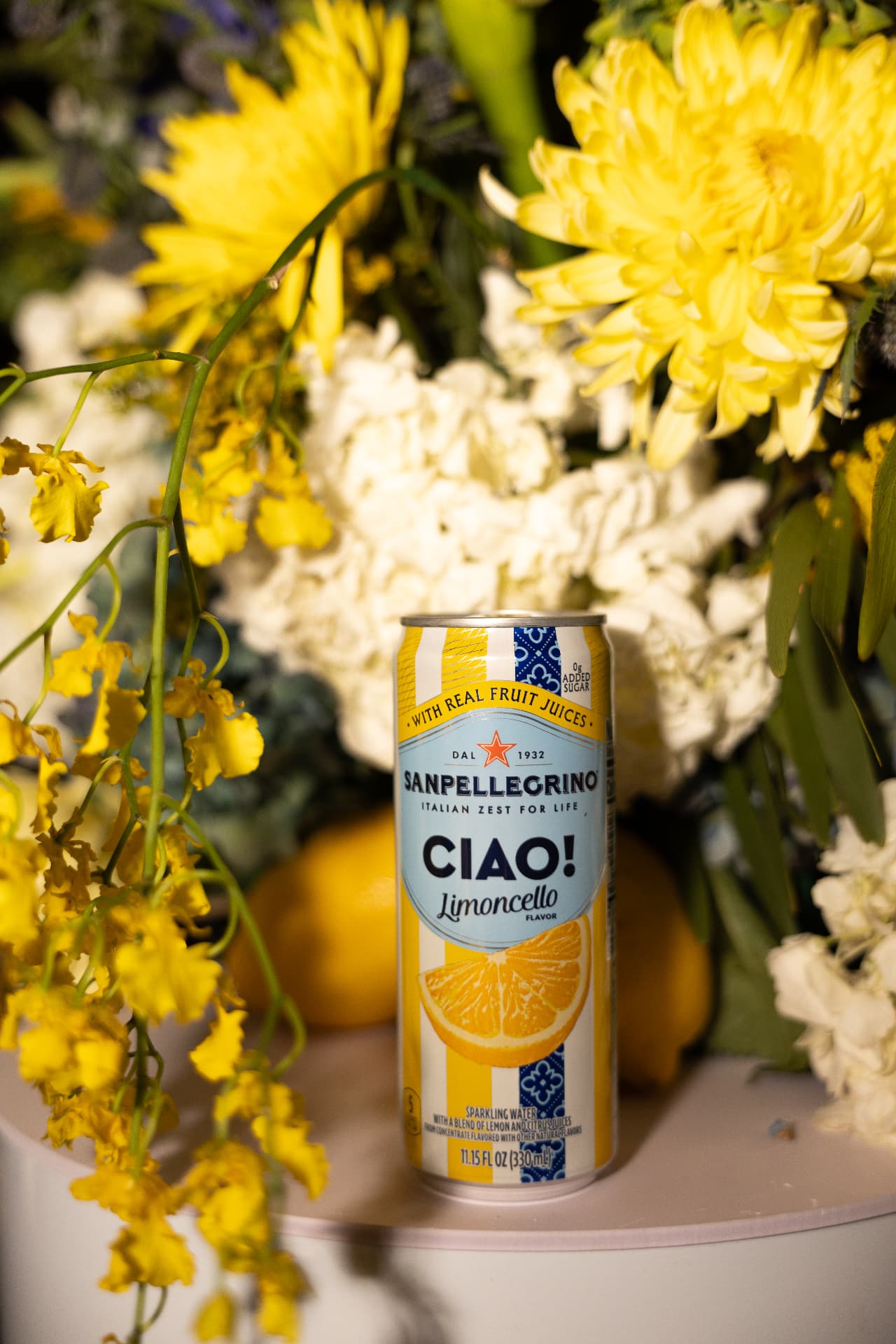 Sanpellegrino CIAO! Limoncello can staged among yellow and white florals