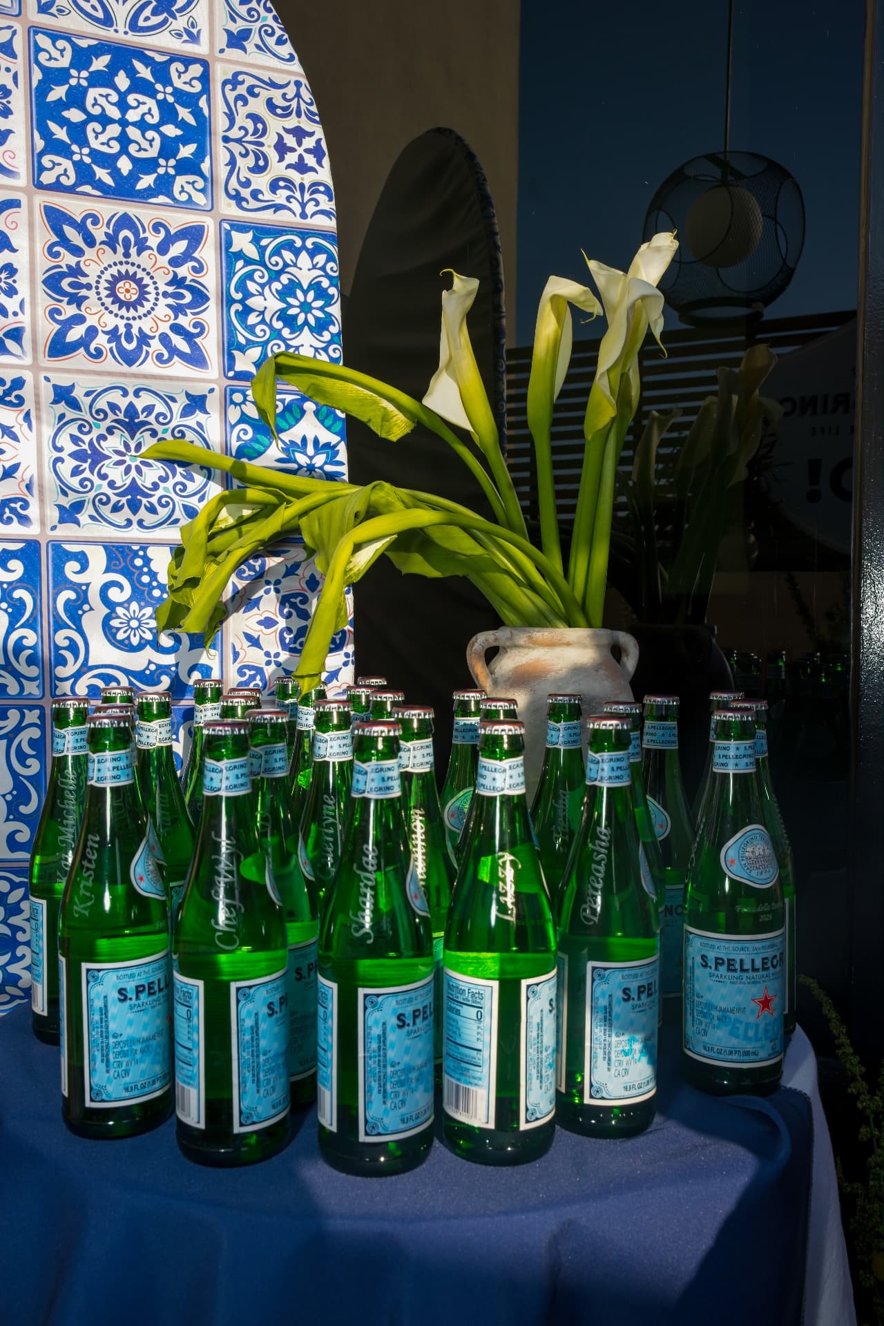 Personalised etched S.Pellegrino bottles against a blue azulejo tile backdrop