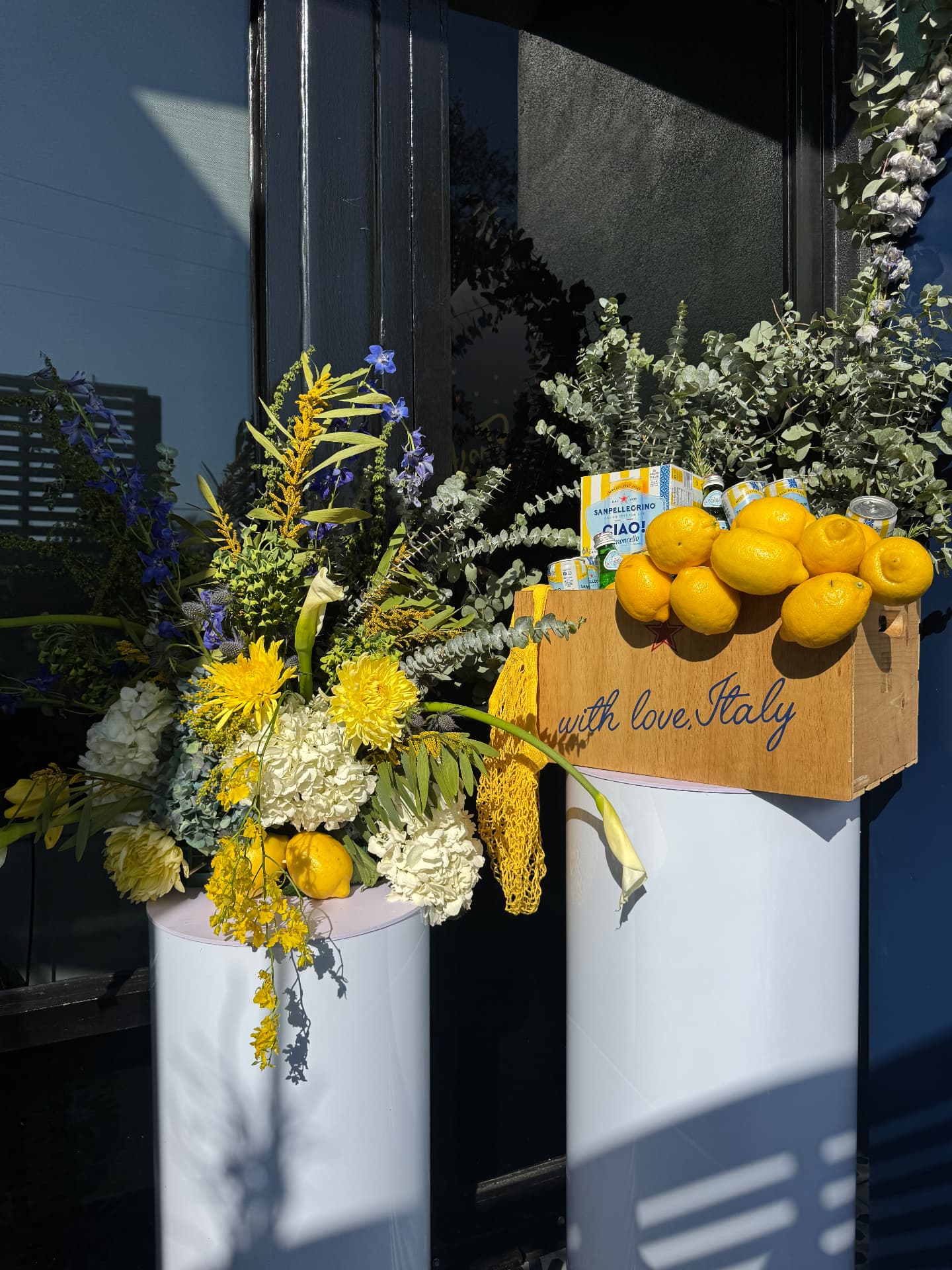 Lemon crate and yellow-and-blue floral pedestals at a Sanpellegrino entry moment